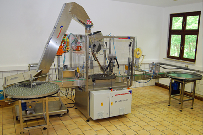 Linear semi-automatic filling, capping and labelling machine from Küppersbusch.